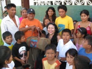 Donation donation distribution charity community kids volunteers smiling people group children helping hands Guatemala social outreach humanitarian aid Asian children charity event with diverse individuals in outdoor setting.