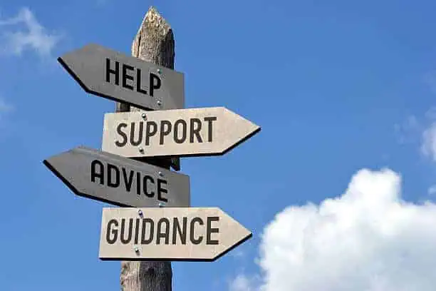 Wooden signpost with arrows labeled Help, Support, Advice, and Guidance against a blue sky background.