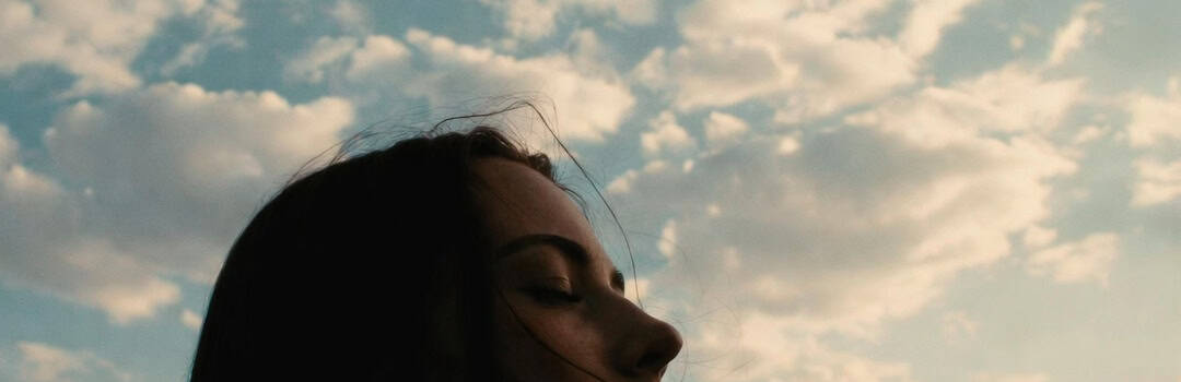 Woman with closed eyes contemplating, symbolizing the power of positive thinking and mindset influence.