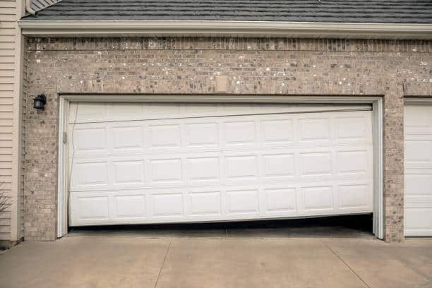 Slanted broken garage door in need of repair