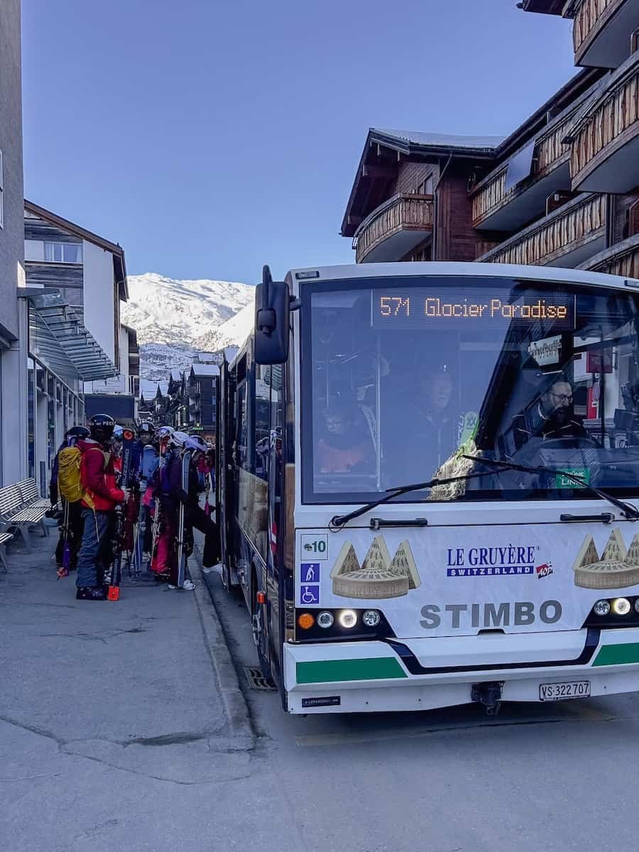 Skiers boarding a bus in Zermatt.