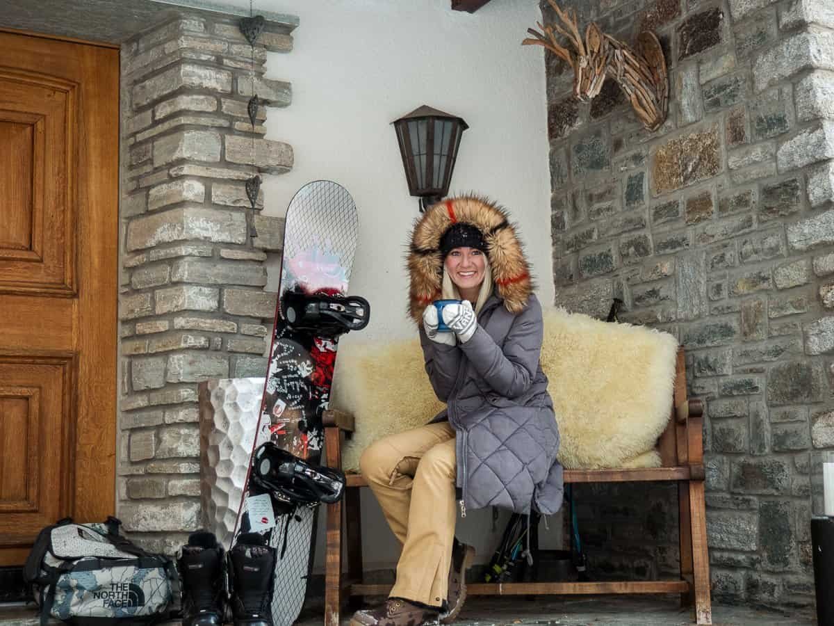 Snowboarder outside chalet in Zermatt enjoying an alcohol-free après ski.