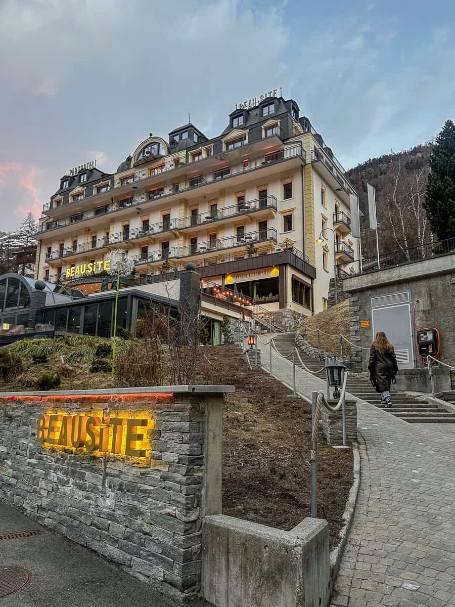 The Beausite hotel in Zermatt, lit up at sunset.