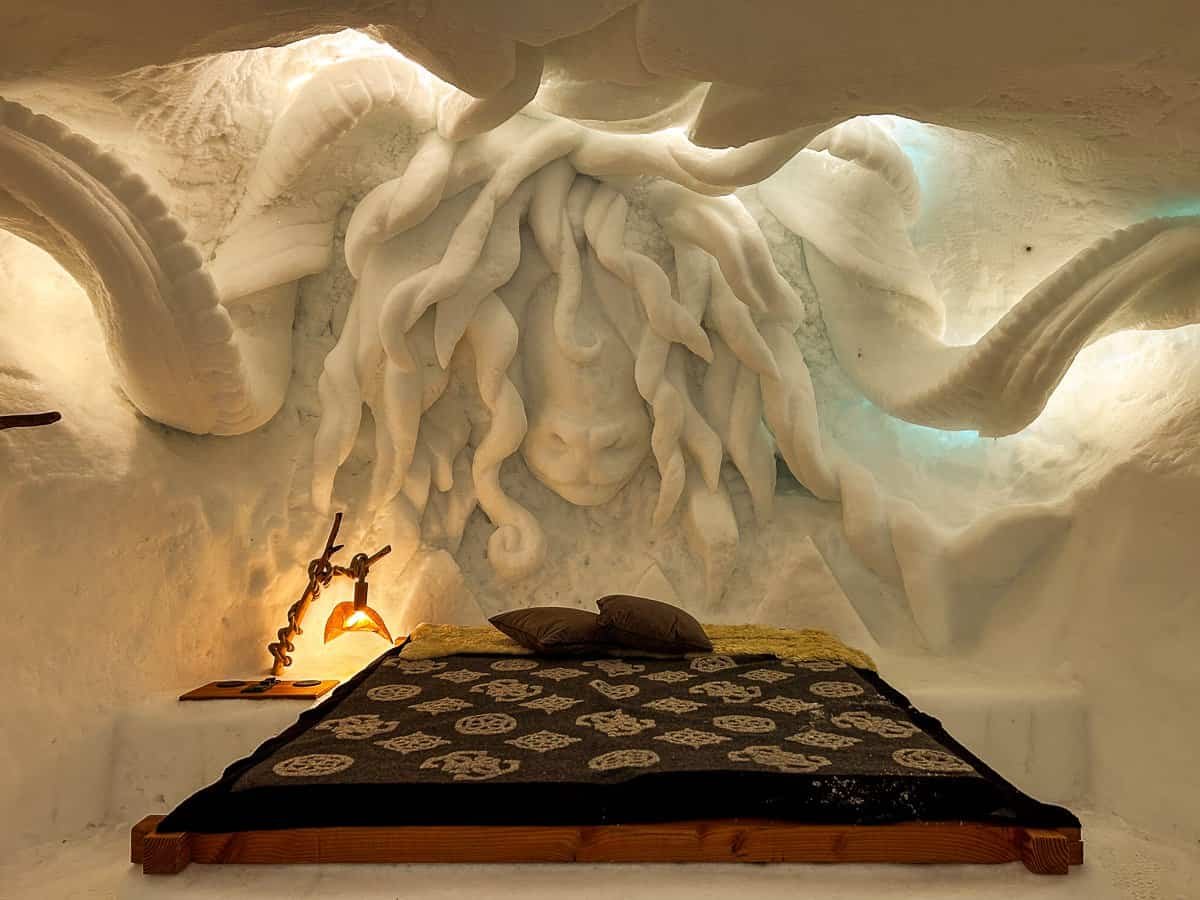 A Ram carved into the wall above the bed of an igloo hotel in Zermatt.