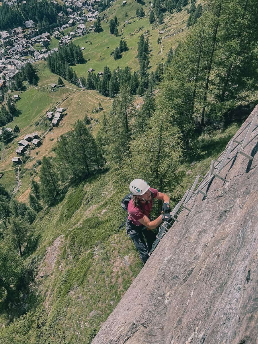 Man climbing the ladder above Zermatt on the via ferrata.