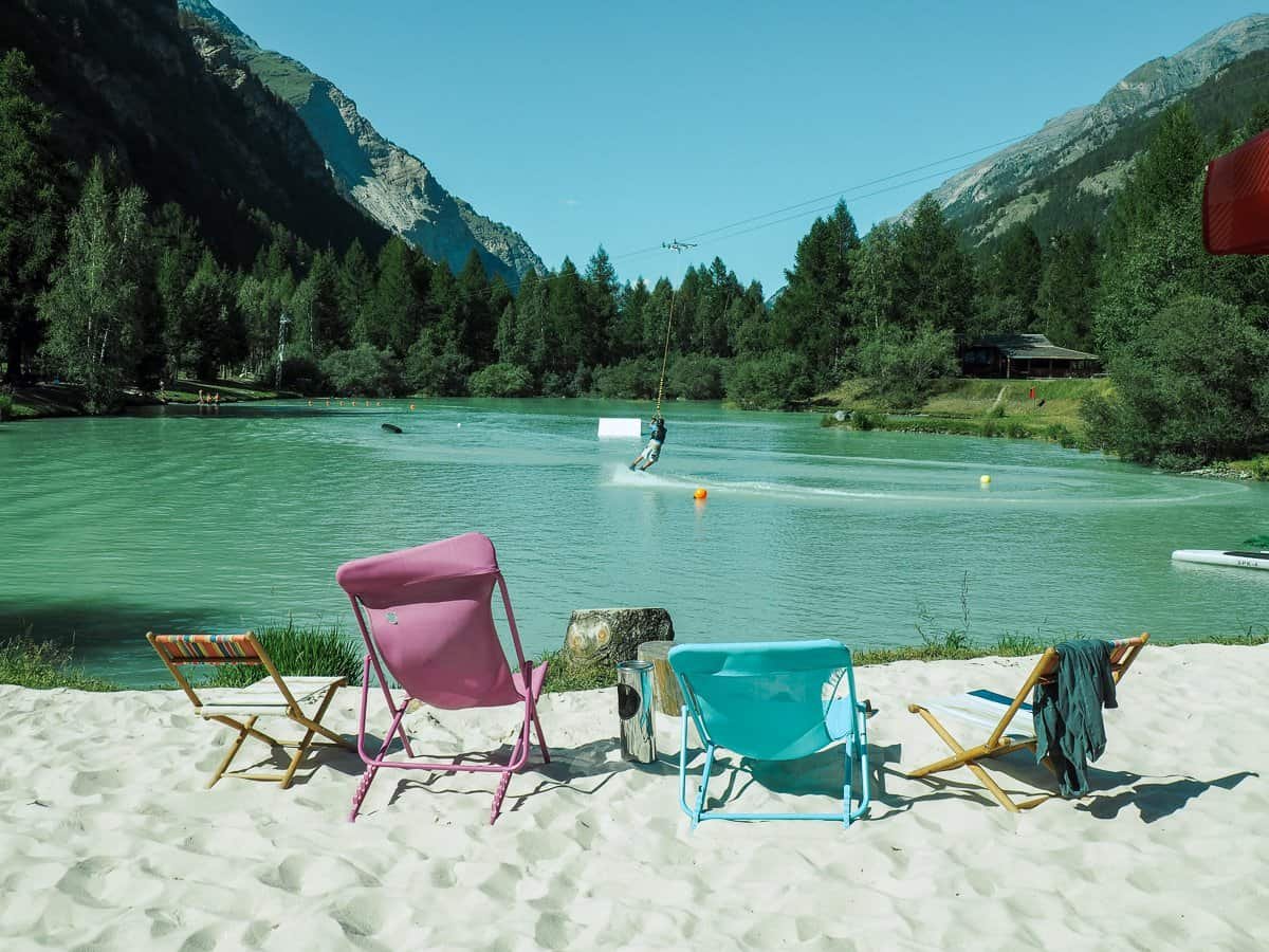 Wakeboarder and deck chairs at Schalisee Lake, Täsch, Switzerland.