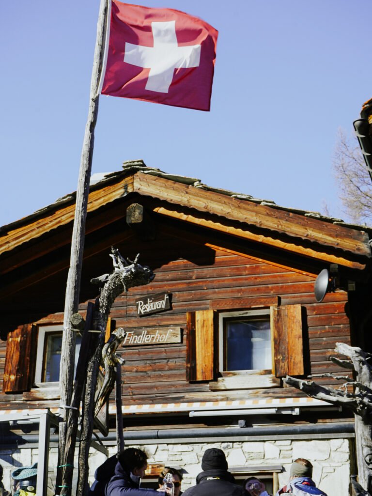 Swiss flag outside of a wooden mountain hut in Zermatt.