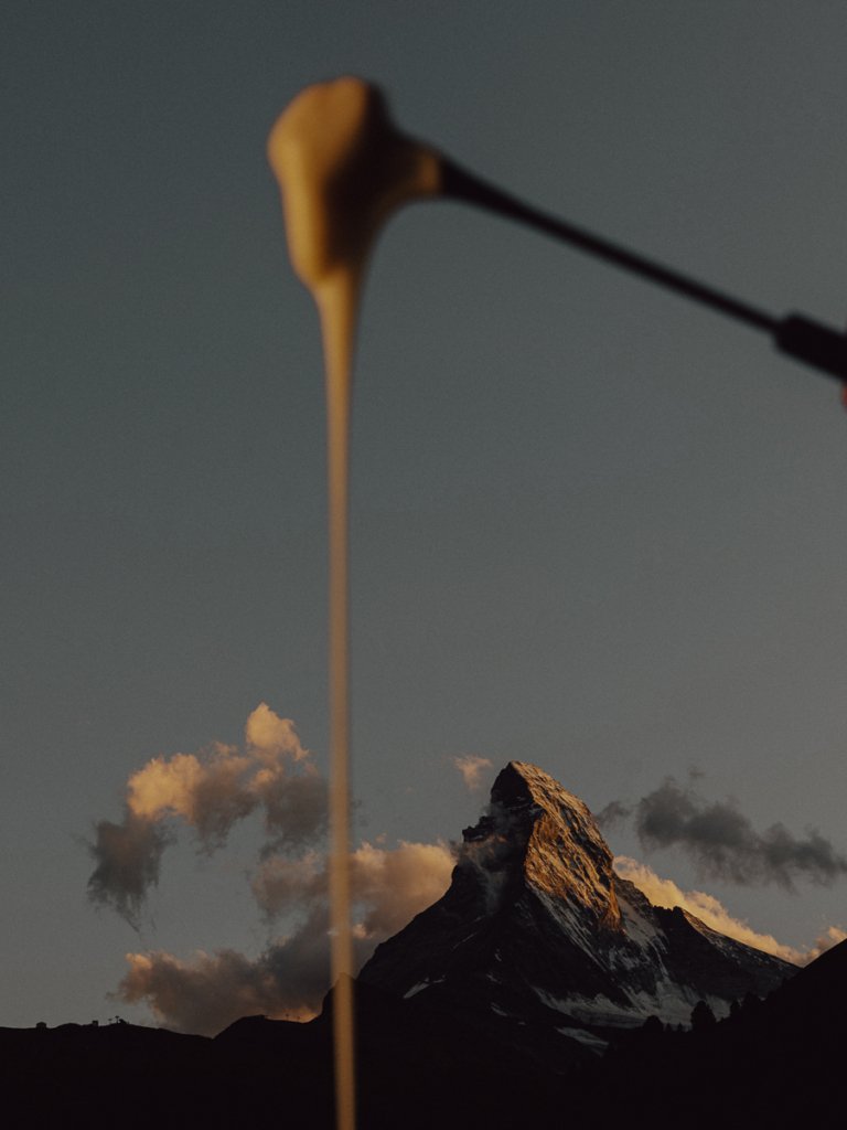 Cheese dripping from a fondue fork in front of the Matterhorn.