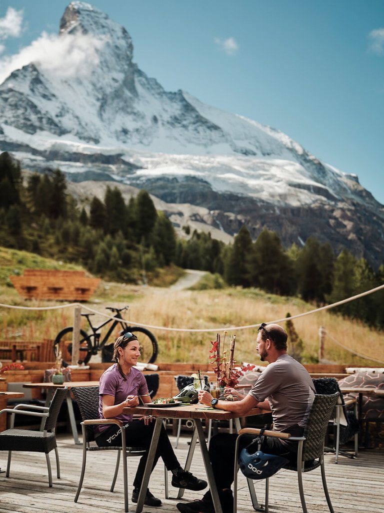Two mountain bikers having lunch beneath the Matterhorn.