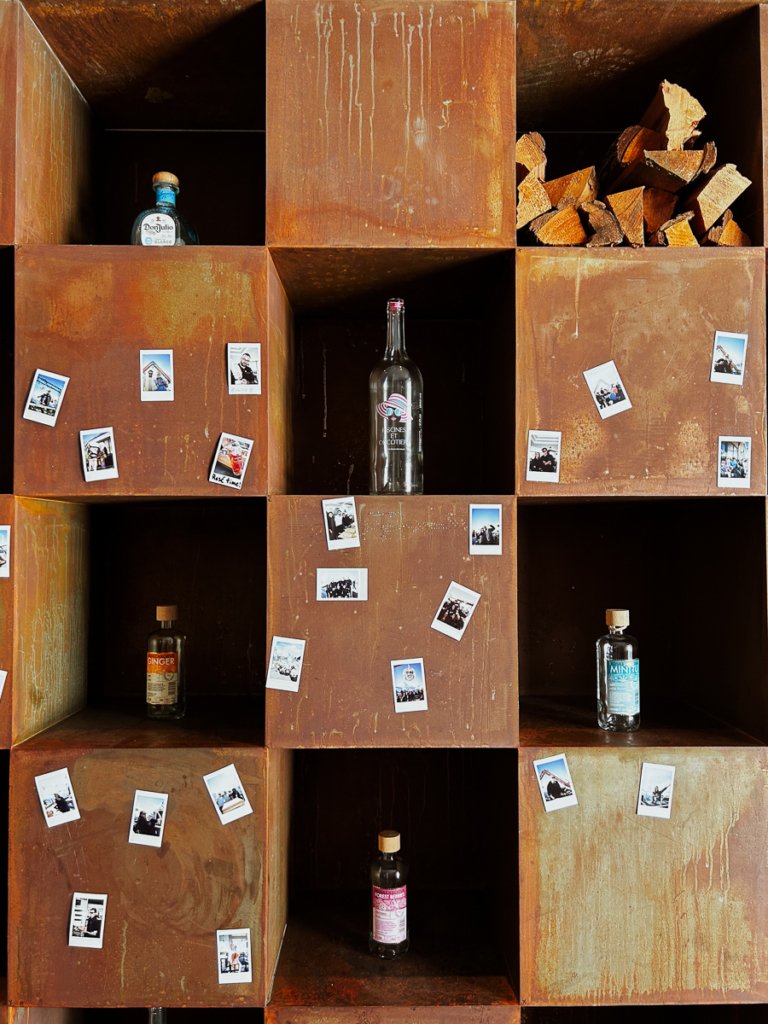 Shelves, bottles and polaroids in Blue Lounge, Zermatt.
