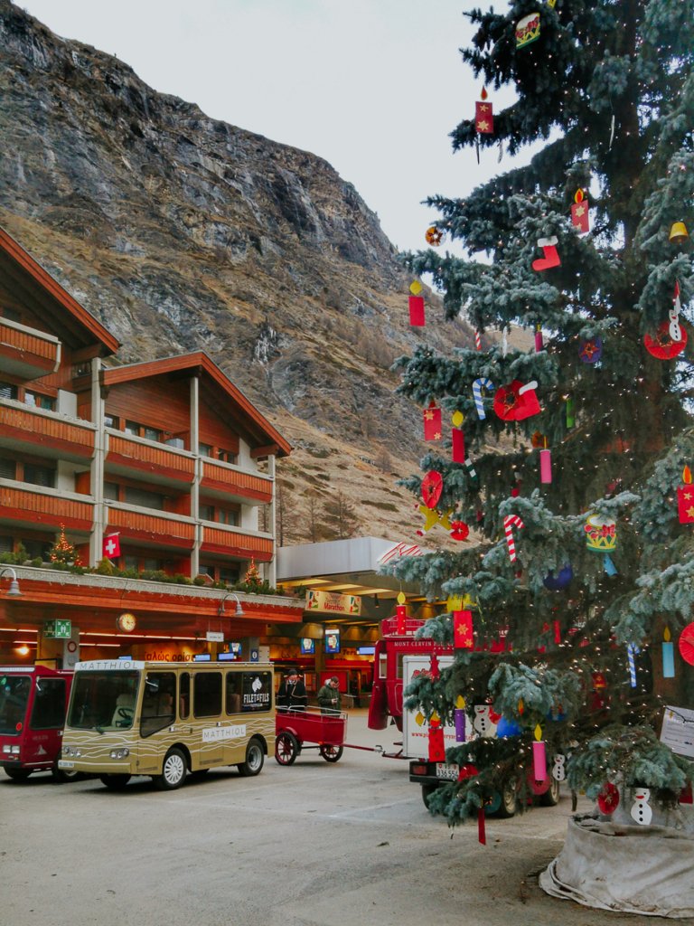 Christmas tree and electro vehicles at Zermatt train station.