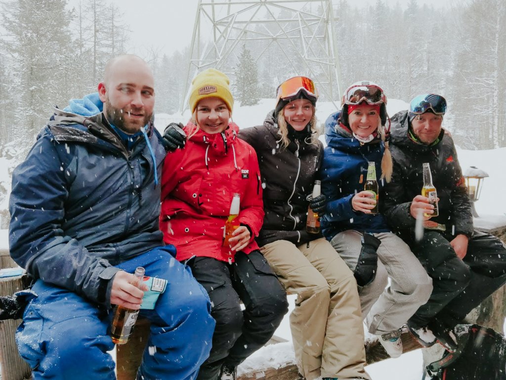 Skiers enjoying après ski, drinking in the snow at Hennustall, Zermatt.