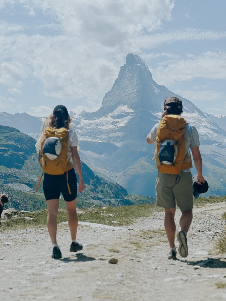 Couple walking in front of the Matterhorn in summer.