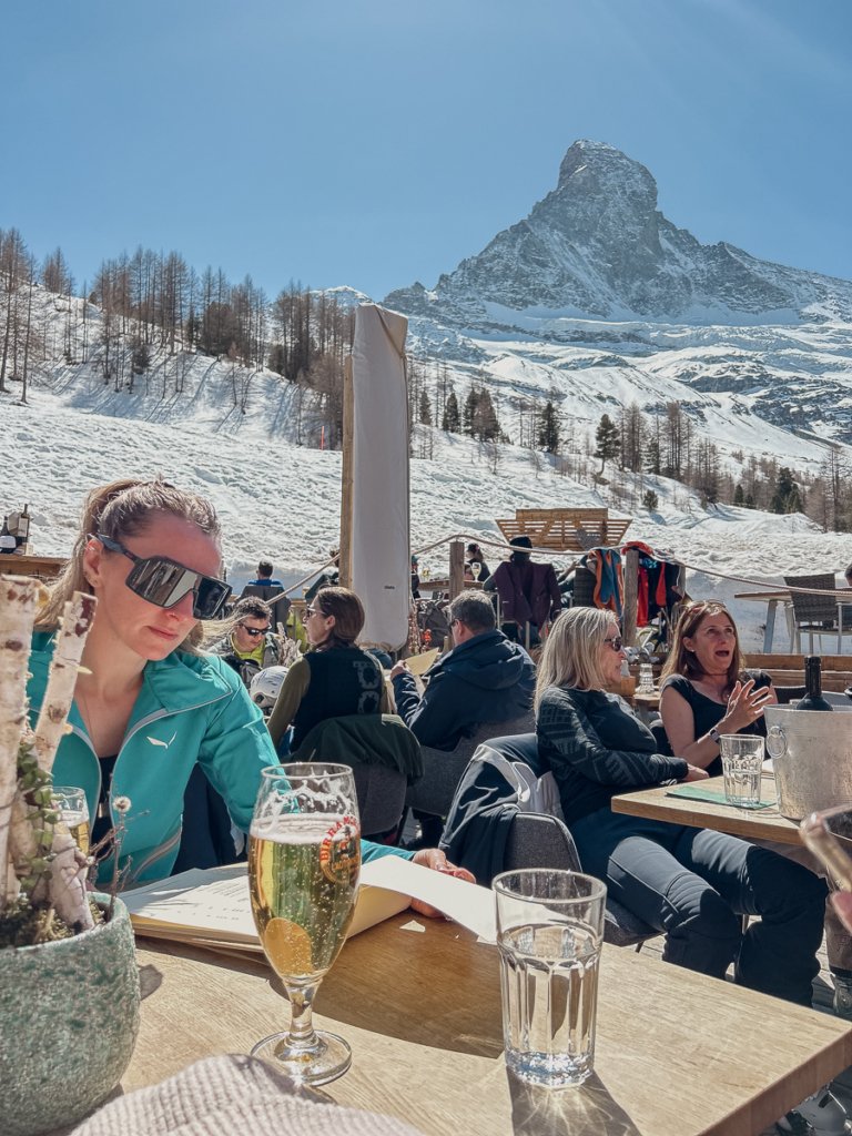 Woman sat at a restaurant table underneath the Matterhorn.
