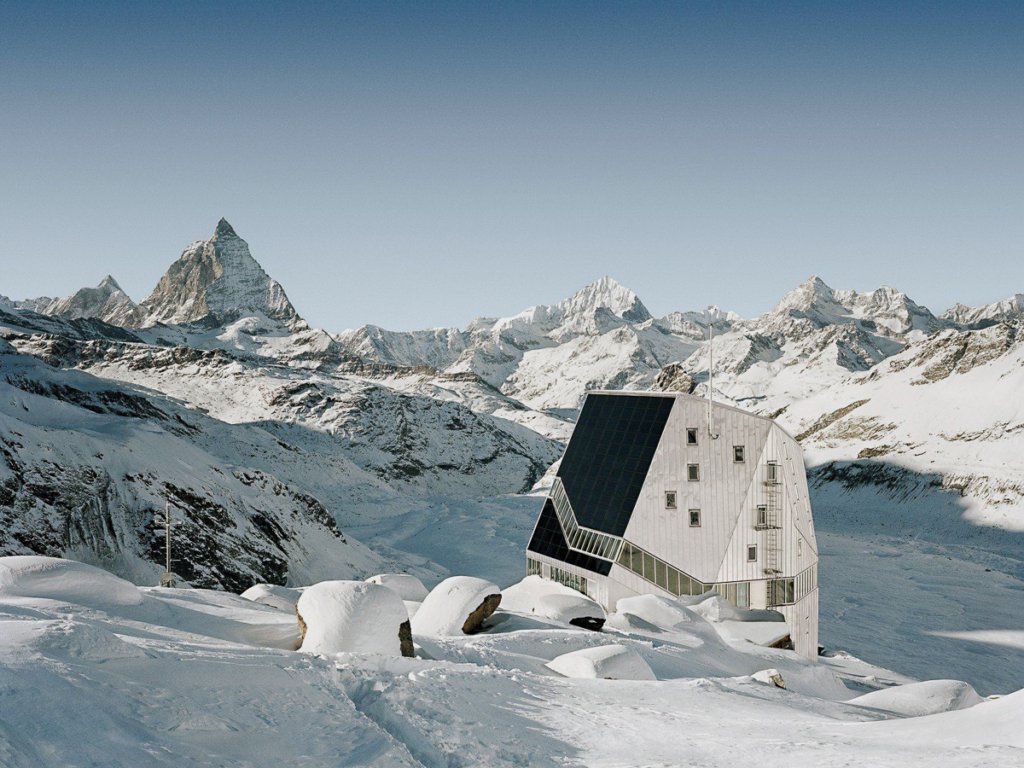 A mirror-covered mountain hut, among the snowy, Swiss Alps. Monte Rosa Hütte is where to stay in Zermatt for alpine climbers.