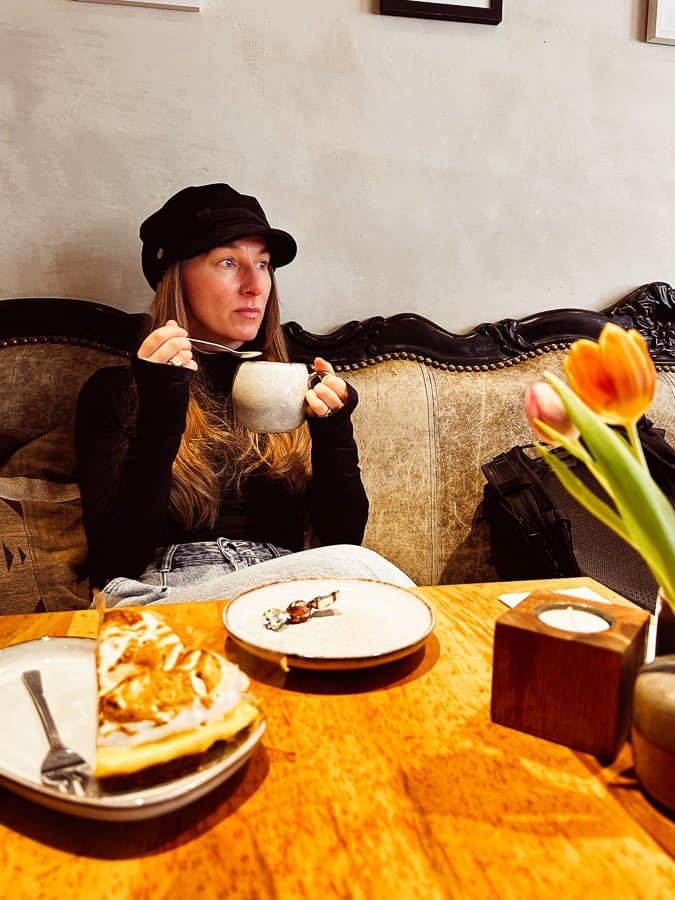 Woman drinking a hot chocolate in Petit Royal, Zermatt.