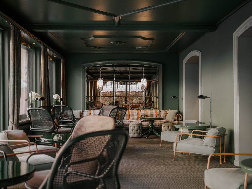 Luxury hotel bar in teal, soft greens and neutral tones at BEAUSiTE Zermatt.