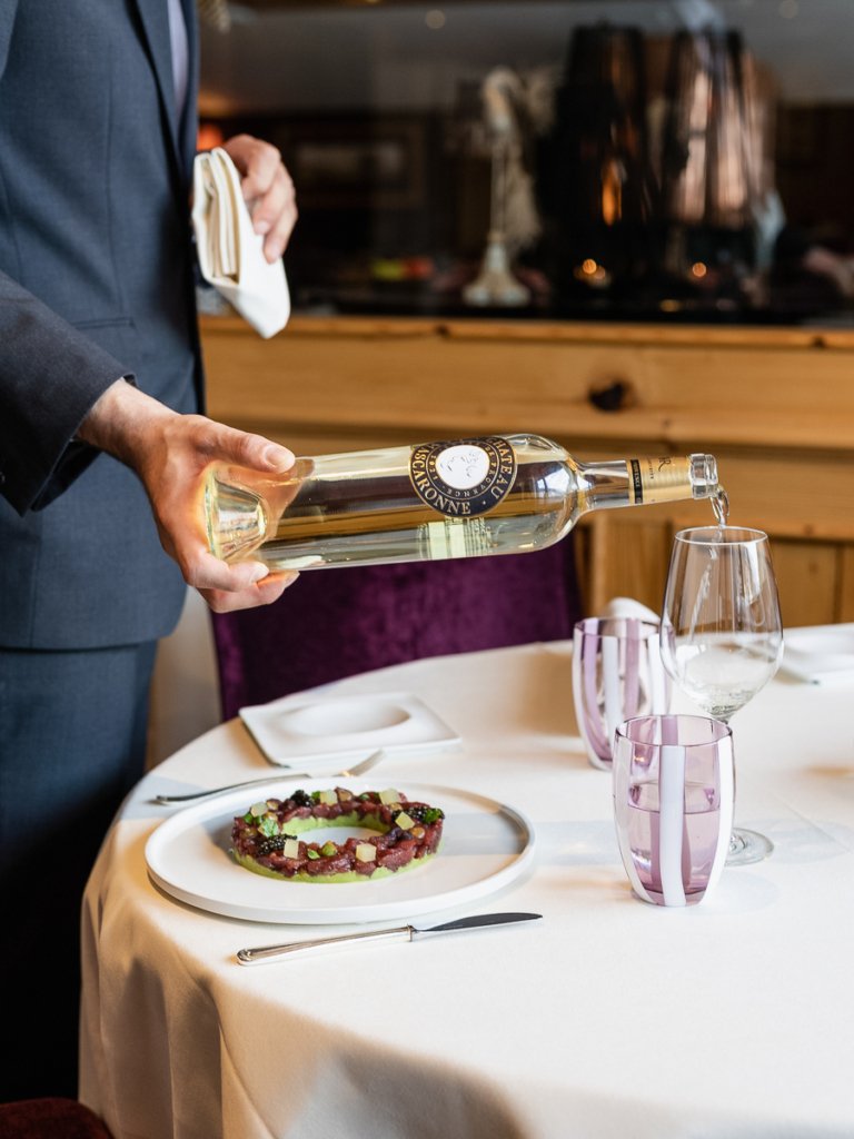 A waiter pouring wine at Ristorante Capri in Zermatt.