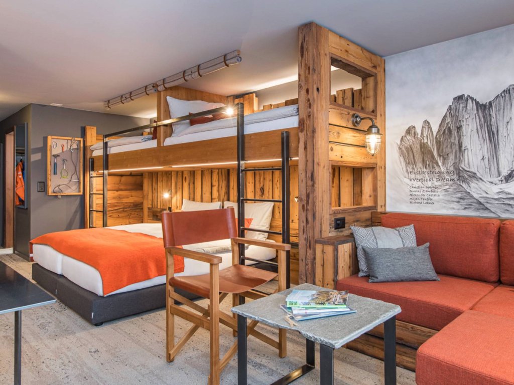 Cozy mountain-themed hotel room with bunk beds, warm wood accents, and modern decor in a budget hotel in Zermatt.