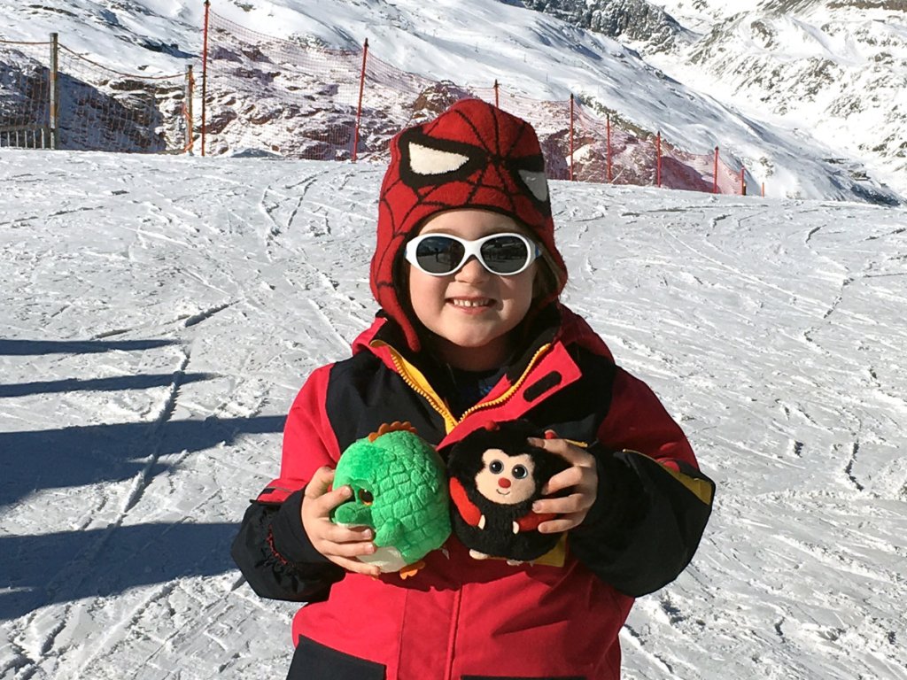 child playing on the snow-covered slopes with Alpine Nanny in Zermatt Switzerland