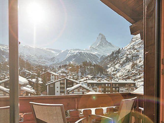 Vibrant Swiss mountain view from a budget hotel in Zermatt during winter.