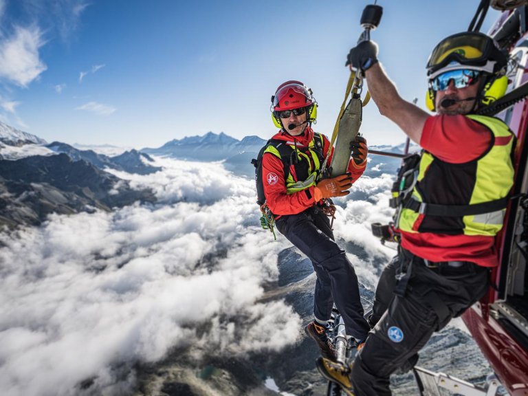 Michael Portmann hanging out of an Air Zermatt helicopter.
