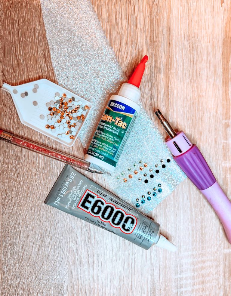 rhinestones on a table along with the e6000 glue, gem-tac glue and a hotfix rhinestone applicator