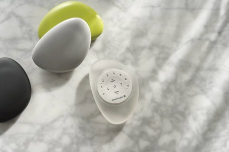 Smart kitchen egg timer on marble surface for cooking precision.