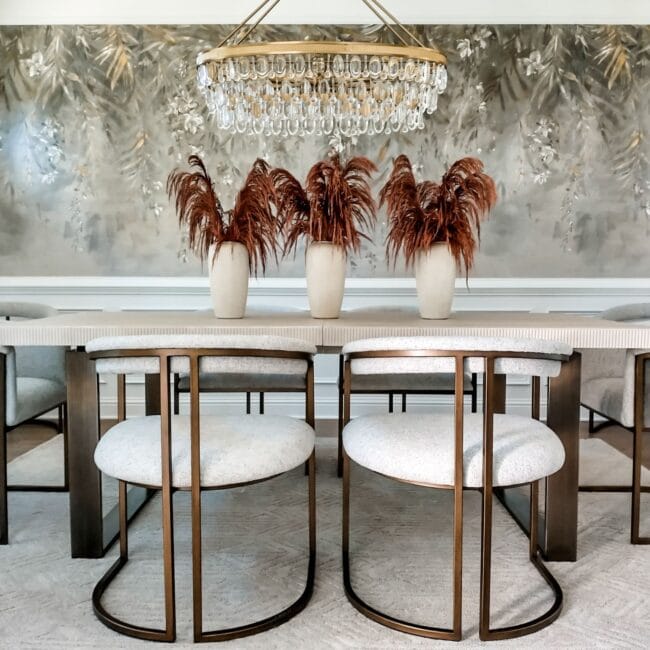 Luxurious dining room with stylish chairs, a crystal chandelier, and artistic wall decor, perfect for upscale interiors.