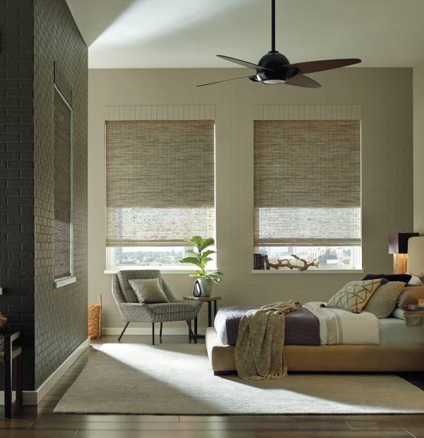 Spacious bedroom featuring natural light, stylish blinds, and cozy interior design.
