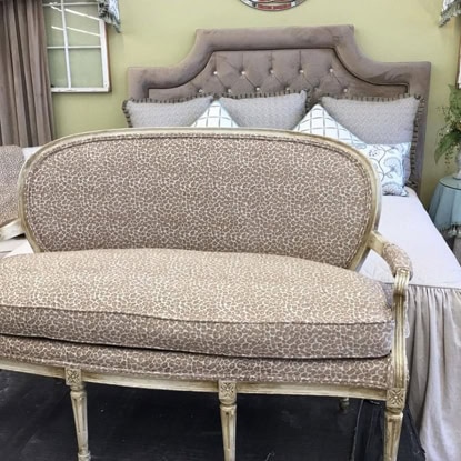 Chic vintage-inspired upholstered bedroom sofa with carved wood frame and classic design.