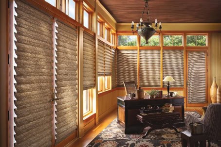 Bright sunroom with woven wooden blinds and large windows.