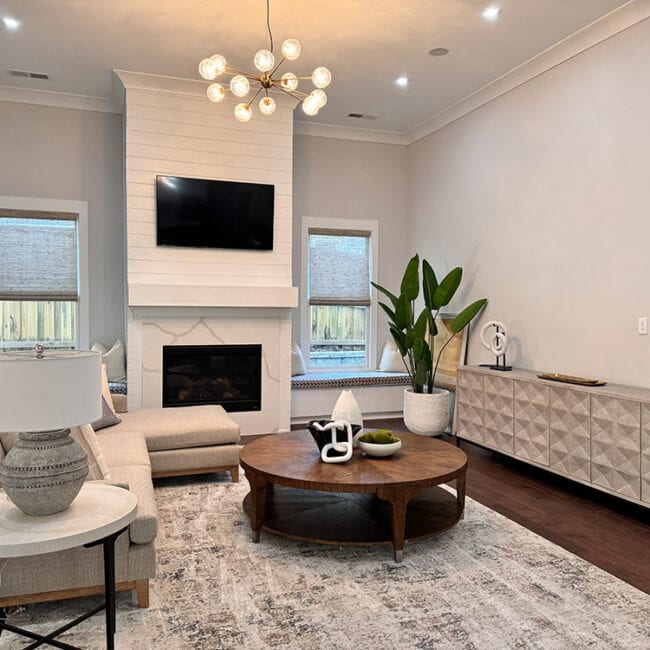 Bright living room with fireplace, TV, and stylish furniture.
