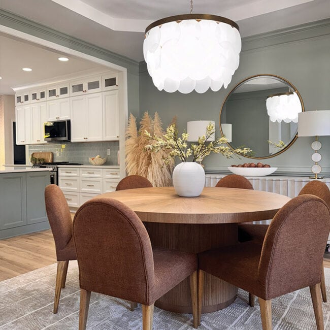 Stylish dining room with round table, brown chairs, and modern lighting fixture.