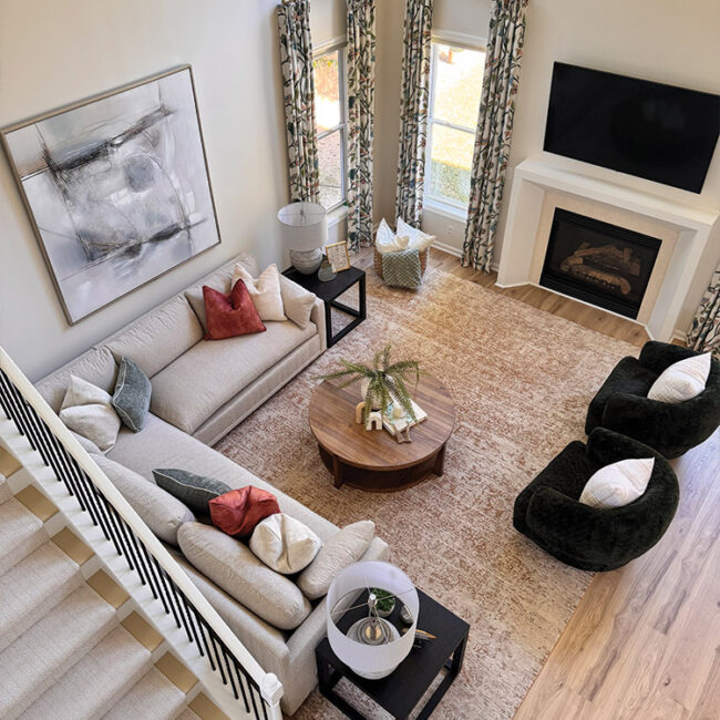 Bright living room with large windows, stylish furniture, and a fireplace.