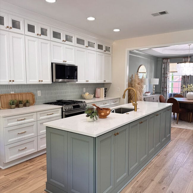 Bright kitchen with white cabinets, blue island, and modern appliances.