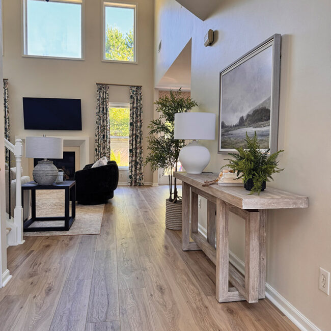 Spacious living room with large windows, modern decor, and a cozy seating area.