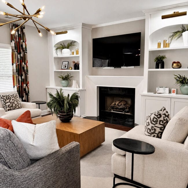 Cozy living room with fireplace, TV, and stylish decor.