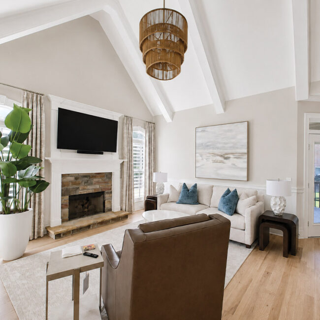 Spacious living room with white walls, large window, and cozy furniture.