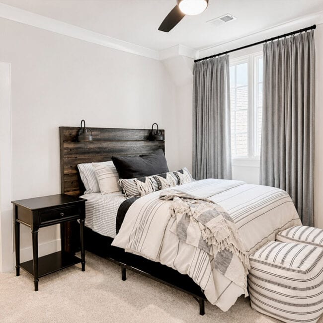 Bright bedroom with large window, neutral decor, and cozy seating.