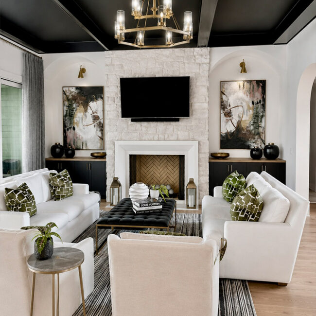 Elegant living room with white sofas, black ceiling, and a fireplace with a TV above.