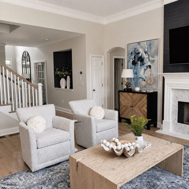 Bright living room with gray armchairs, fireplace, and contemporary decor.