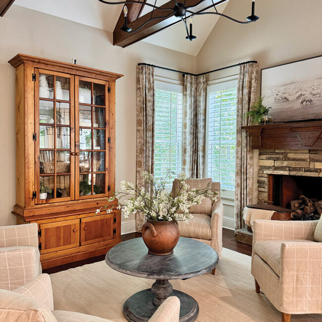 Elegant living room with fireplace, wooden cabinet, and large windows.
