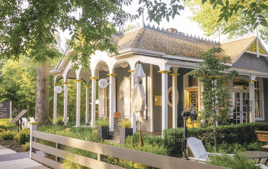 A house with a porch and chairs in front of it.