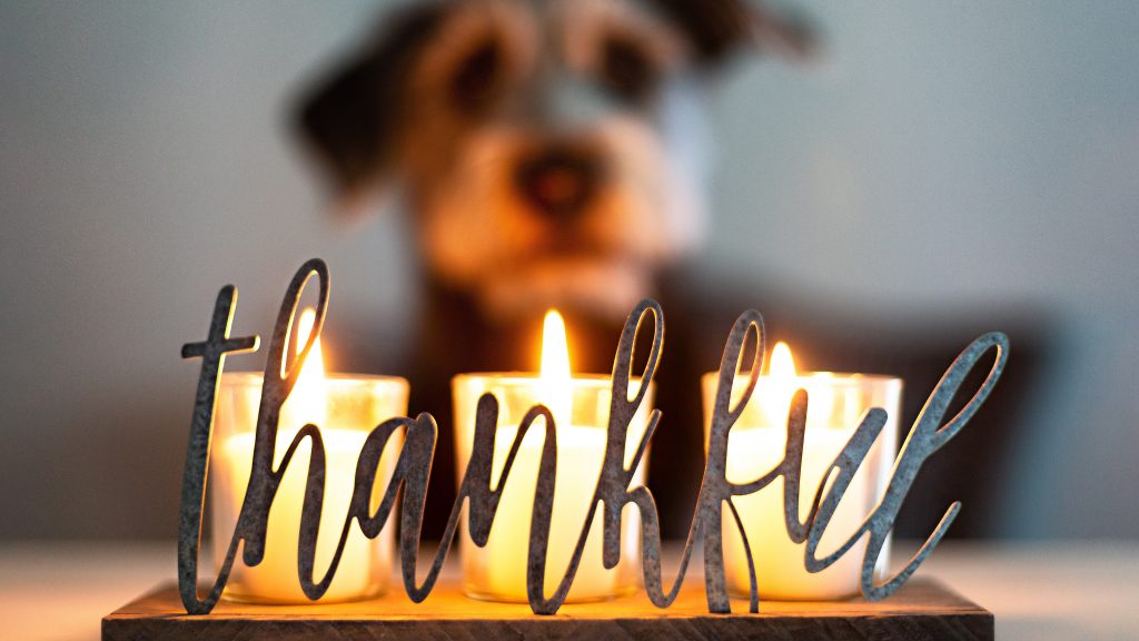 A set of candles flicker gently, casting a warm glow around the word