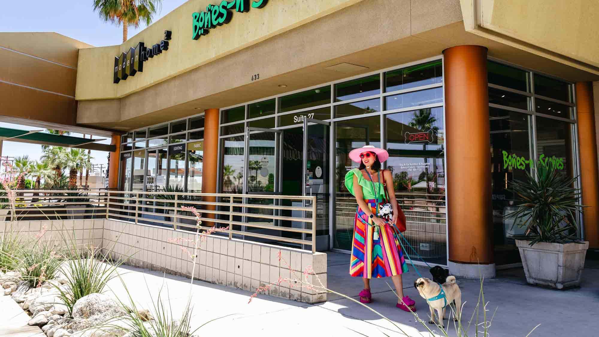 Woman and dog walking by a shop in Greater Palm Springs