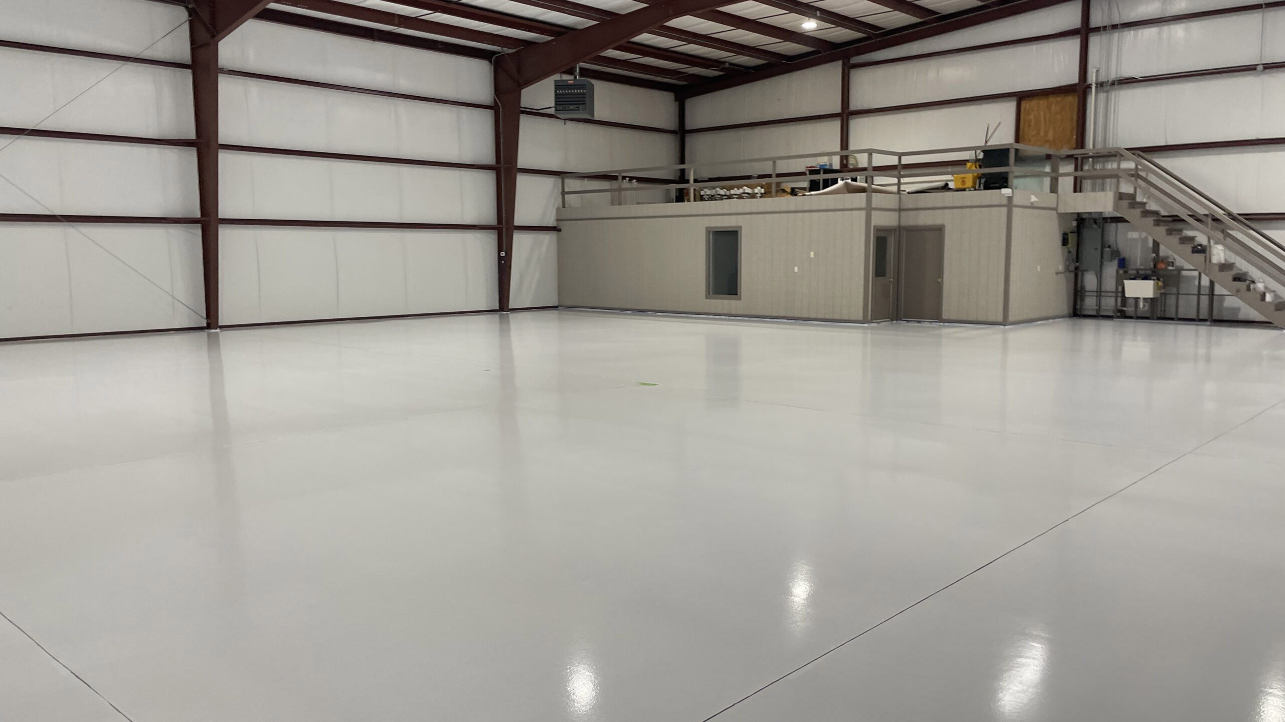 A spacious room with an epoxy coating floor, and a loft. DPM Surface Care