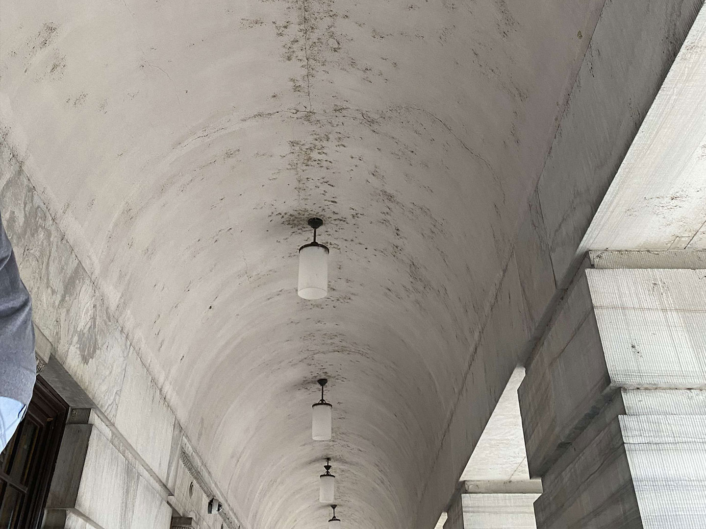 A long hallway ceiling with black spots, before high surface cleaning. DPM Surface Care