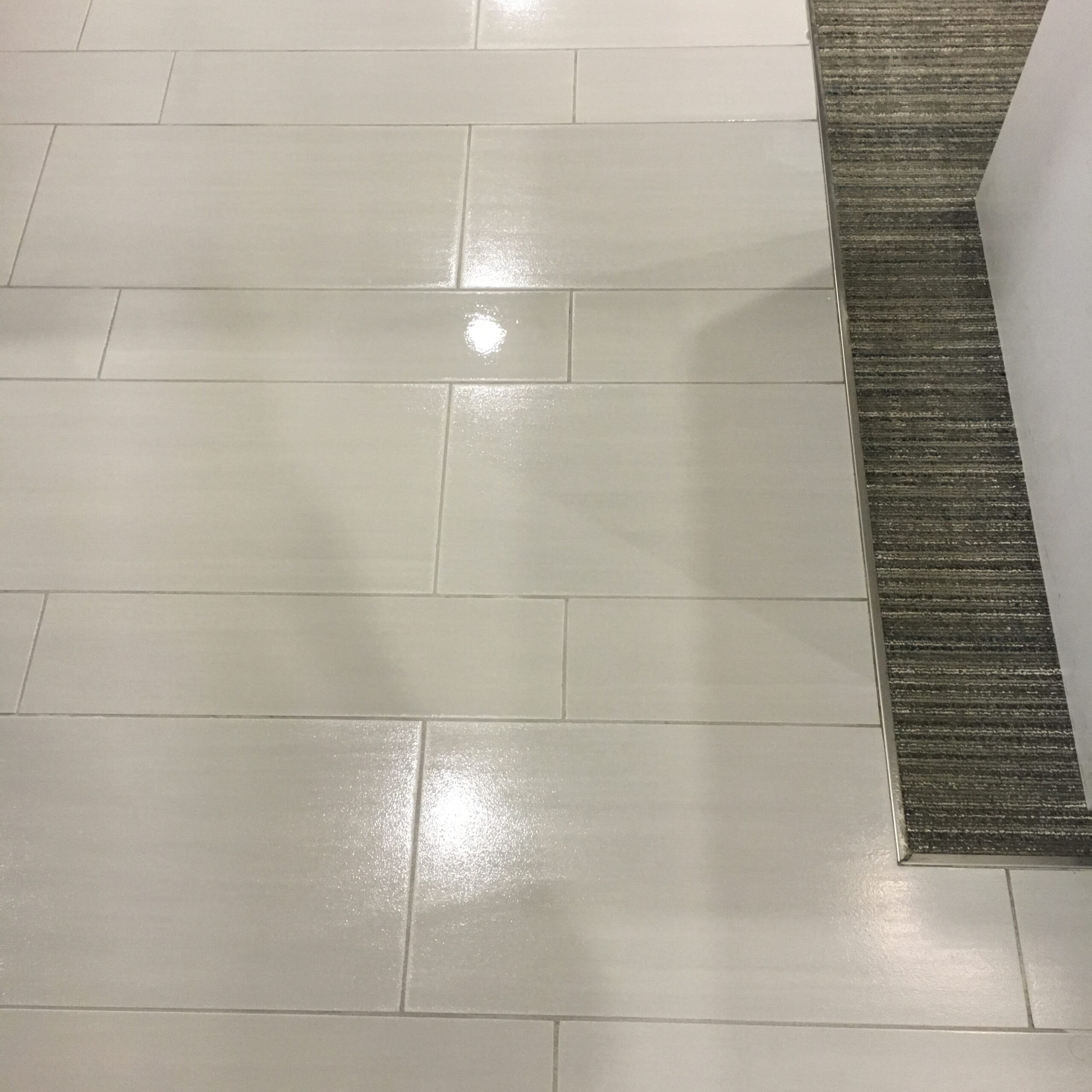 A clean and shiny white tile flooring with a clean grout. DPM Surface Care