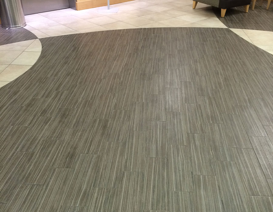 dpm-surface-care-tile-and-grout-before A combination of white and gray, clean tile flooring with cleaned grout in a commercial office. DPM Surface Care